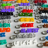 Assorted custom 3D printed name keychains in many colours by Swag Layers
