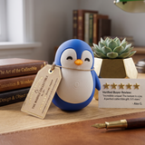 Blue chubby penguin figurine on a wooden desk with books and a succulent
