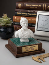 White Chhatrapati Shivaji Maharaj mini statue on a wooden base on a desk