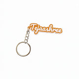 Orange and white 2-colour 3D printed name keychain reading Tejaashree