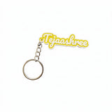 Yellow and white 2-colour 3D printed name keychain reading Tejaashree