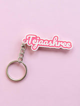 Pink and white 2-colour name keychain reading Tejaashree on a pink background