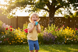 Boy blowing a 3D printed bird whistle in a backyard garden