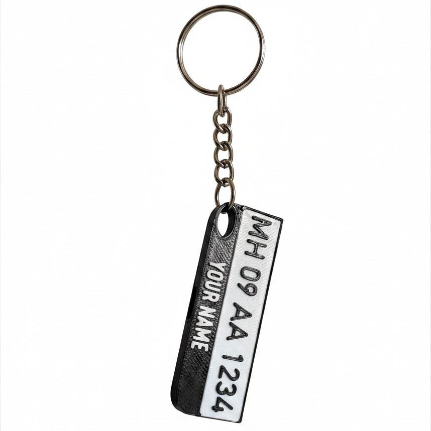 Swag Layers personalized Indian number plate keychain with a built-in emergency safety whistle in black and white.