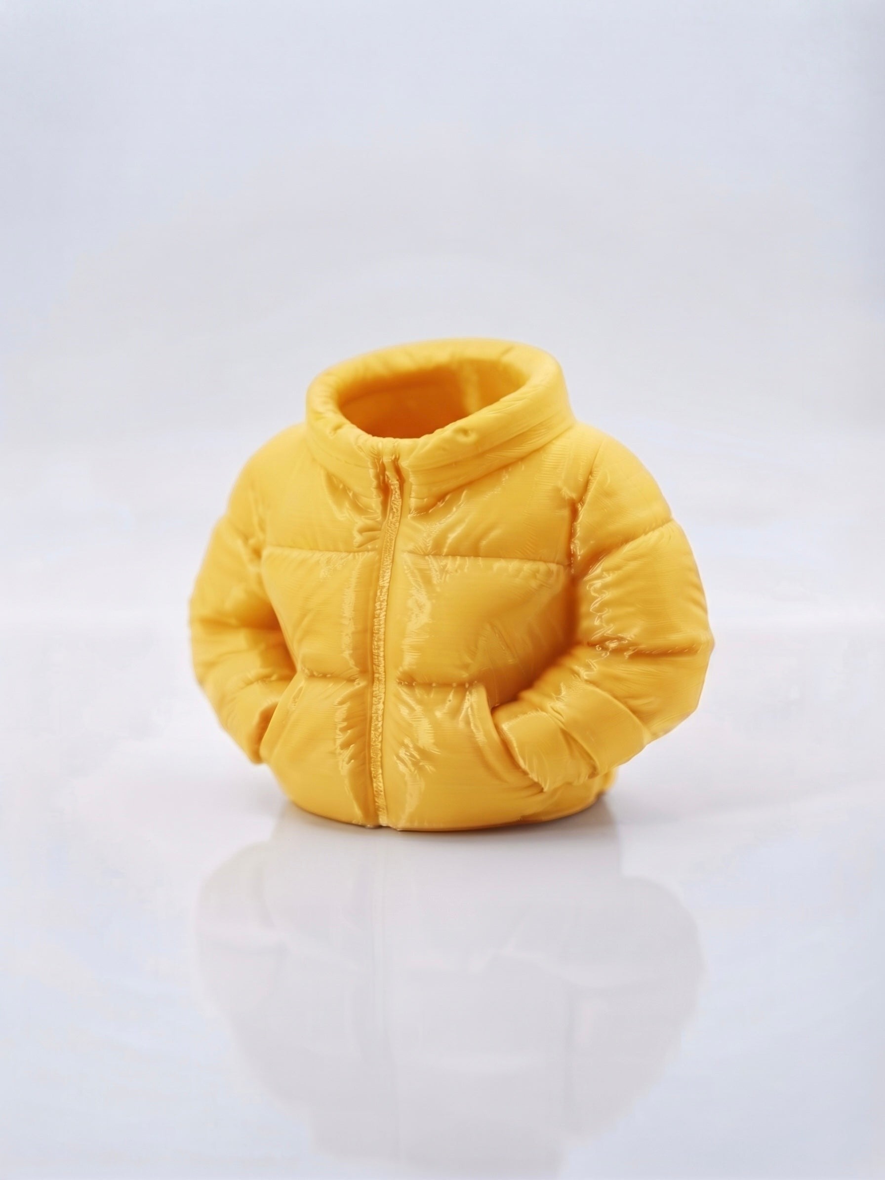 Swag Layers 3D printed yellow puffer jacket desk pen holder with realistic quilted texture and zipper detail.